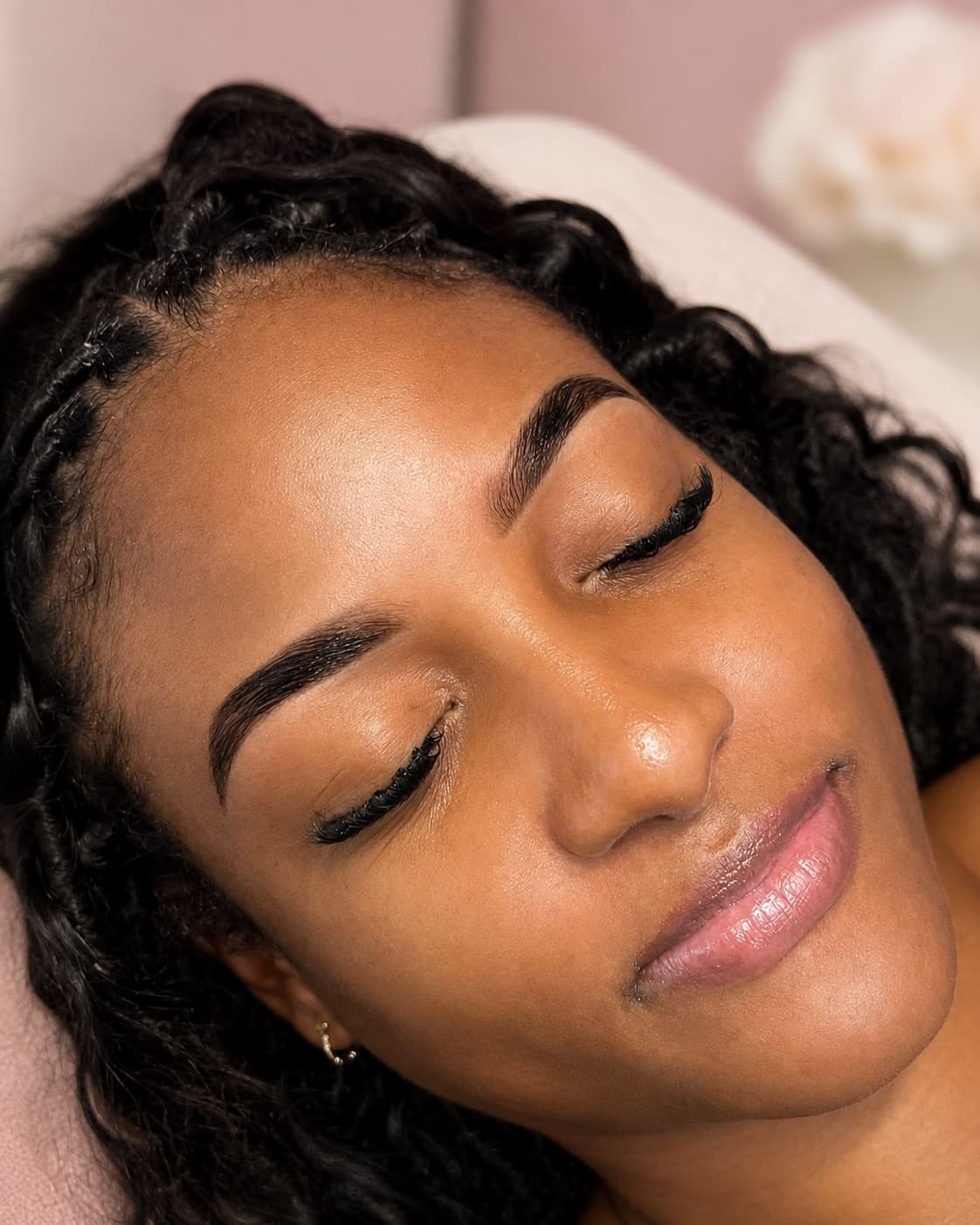 Freshly sculpted and tinted brows with a soft liner, shot on the treatment bed