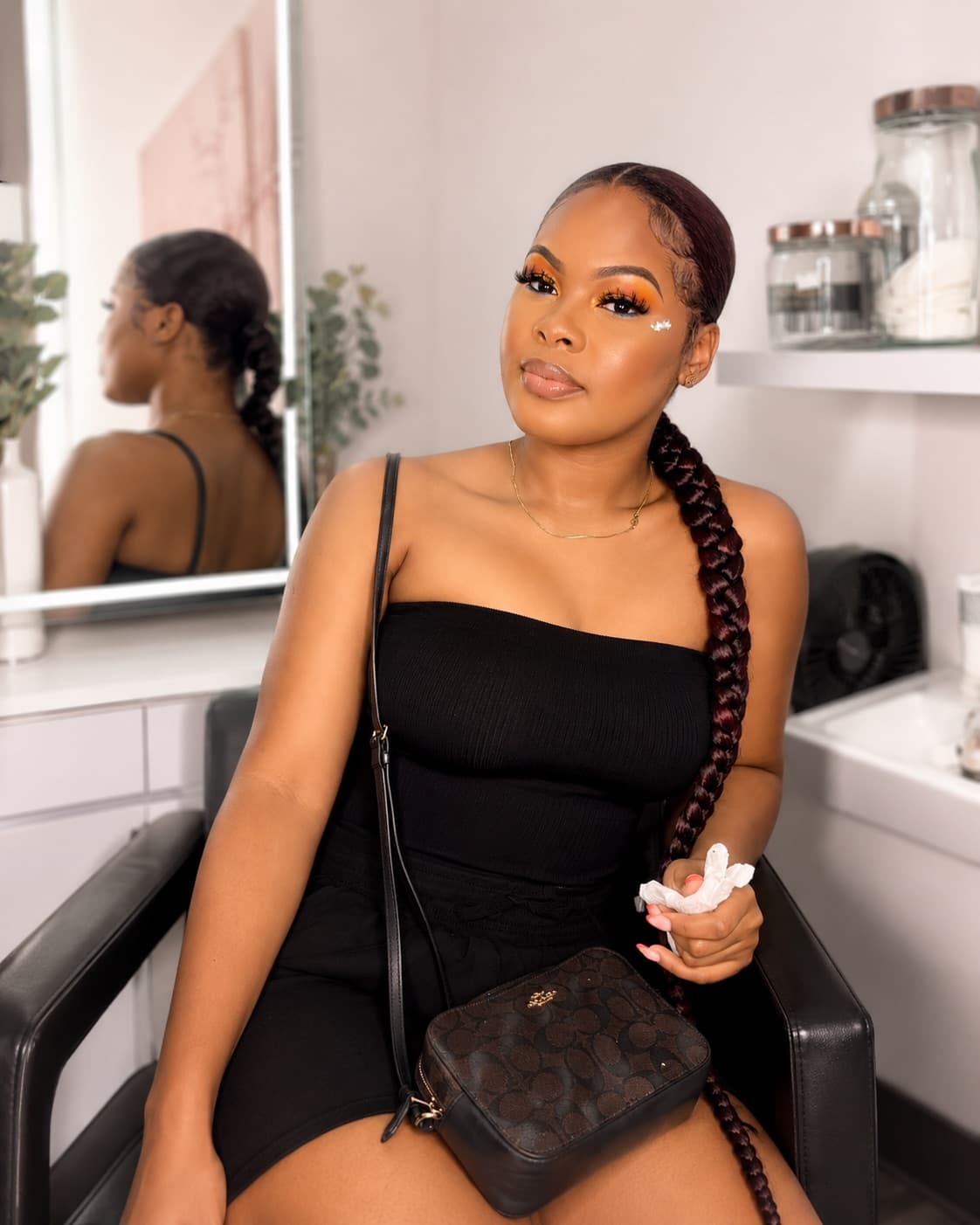 Graphic tangerine liner with crystal detail, shot at the studio vanity