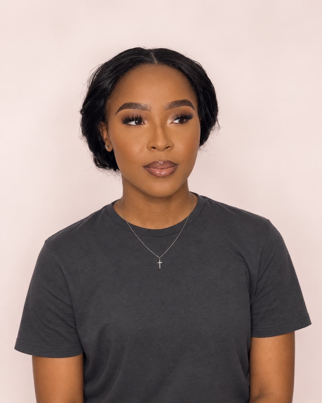 A soft glam finish with a nude lip, shot against the studio's cream wall